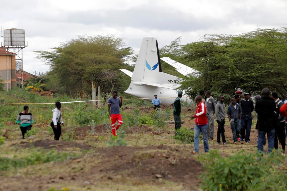 Bystanders watch the Fokker 50, 5Y-IZO plane operated by Silverstone Air that crash landed after take-off from the Wilson Airport in Nairobi, Kenya Friday. — Reuters