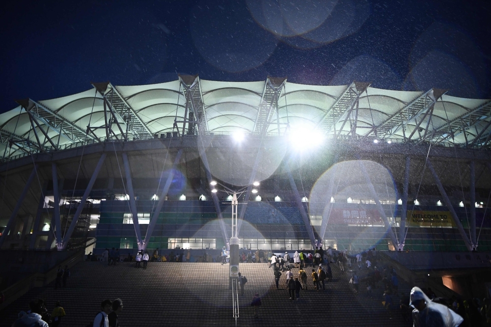 Fans walk in the rain as they arrive for the Japan 2019 Rugby World Cup Pool D match between Australia and Georgia at the Shizuoka Stadium Ecopa in Shizuoka on Friday. — AFP