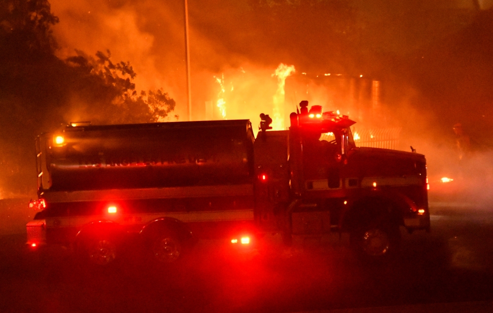 Los Angeles County fire tender is seen during wind-driven wildfire fire in Sylmar, California, on Thursday. — Reuters