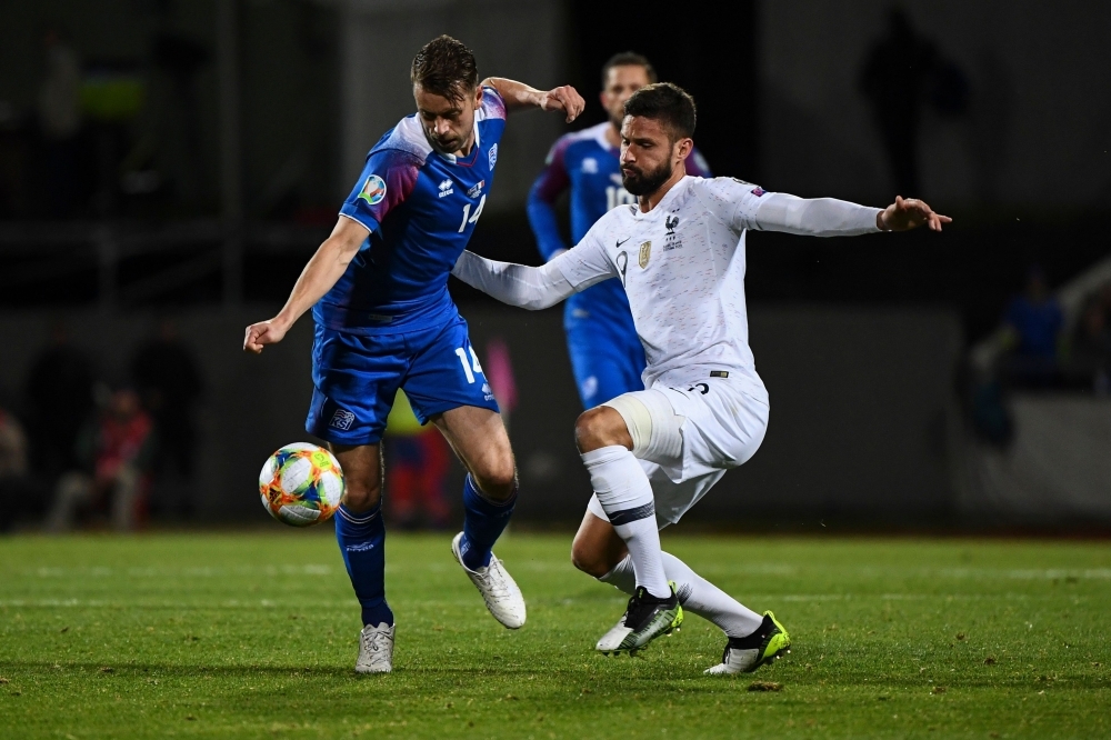 Iceland's defender Kari Arnason (L) and France's forward Olivier Giroud vie for the ball during the UEFA Euro 2020 qualifier Group H football match Iceland v France in Reykjavik, on Friday. — AFP