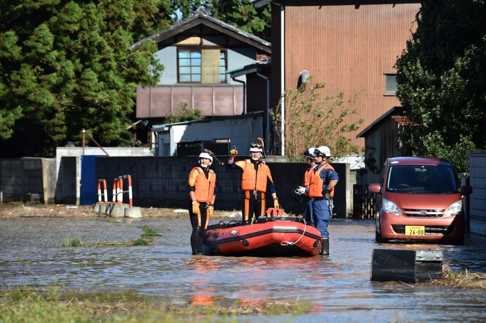 Rescue personnel work in a flooded area in the aftermath of Typhoon Hagibis in Kawagoe city, Saitama prefecture on Sunday. -AFP  