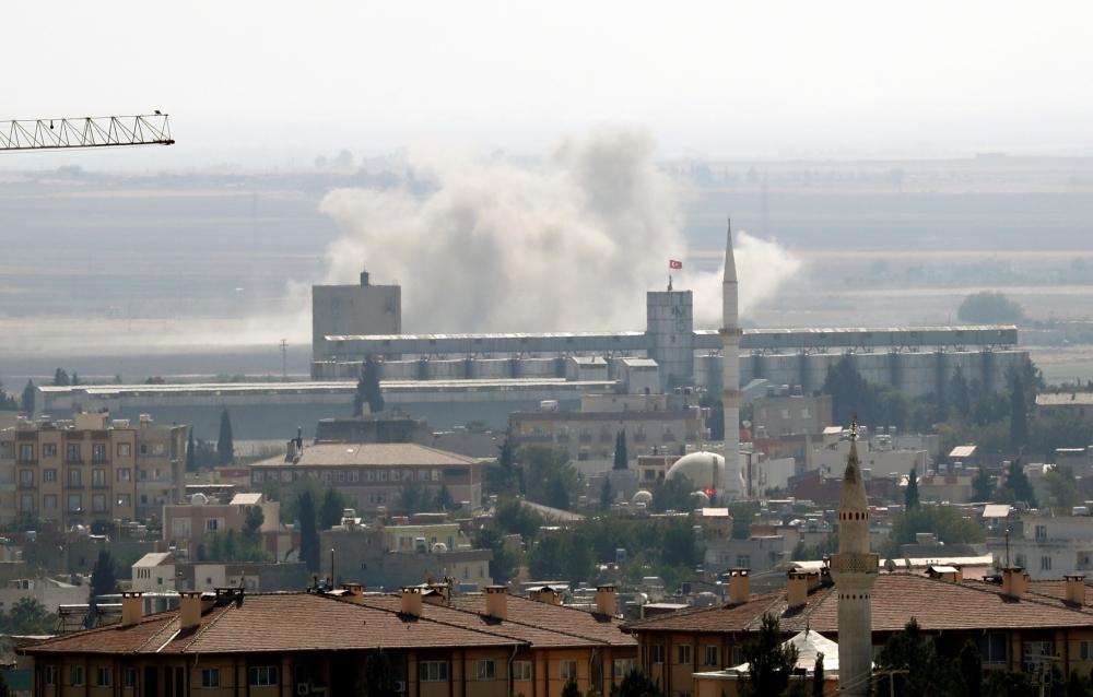 Smoke billows out after Turkish shelling on the Syrian border town of Ras al Ain, as seen from Ceylanpinar, in Sanliurfa province, Turkey, on Sunday. -Reuters