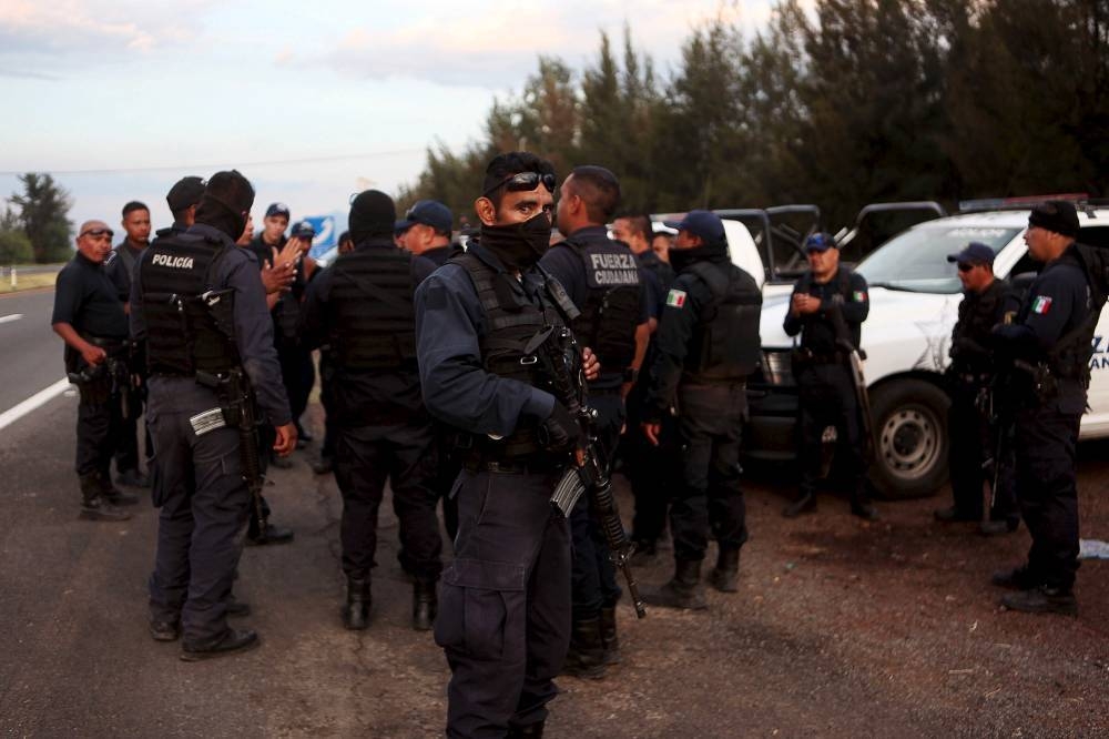 Federal policemen gather outside a ranch where a gunfight between hit-men and federal forces left several casualties in Tanhuato, state of Michoacan, in this May 22, 2015 file photo. — Reuters