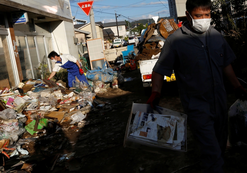 Locals clean a house, in the aftermath of Typhoon Hagibis, in Yanagawamachi district, Date City, Fukushima prefecture, Japan, on Tuesday. — Reuters