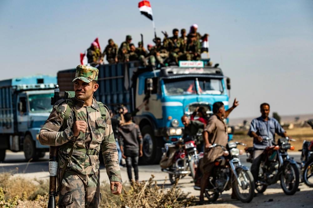 Syrian government forces arrive in the town of Tal Tamr, not far from the flashpoint Kurdish Syrian town of Ras Al-Ain on the border with Turkey, which has been a key target of Turkish forces and their proxies since they launched their military assault, on Tuesday. — AFP