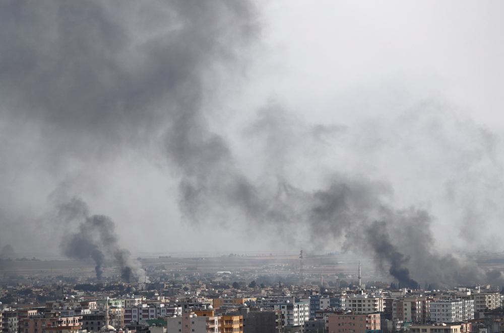 Smoke billows out after Turkish shelling on the Syrian town of Ras Al Ain, as seen from the Turkish border town of Ceylanpinar, in Sanliurfa province, Turkey, on Wednesday. — Reuters