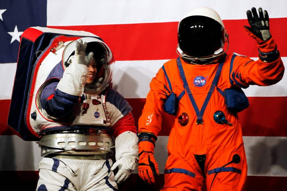 Advanced Space Suit Engineer at NASA Kristine Davis, left, wears the xEMU prototype space suit next to lead engineer Dustin Gohmert wearing the Orion crew survival spacesuit prototype for the next astronaut to the moon by 2024, during its presentation at NASA headquarters in Washington, on Tuesday. — Reuters
