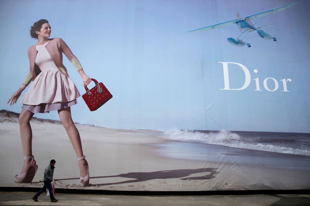 A man walks past a Dior advertisement outside a shopping mall in Wuhan, Hubei province, in this Jan. 19, 2013 file photo. — Reuters