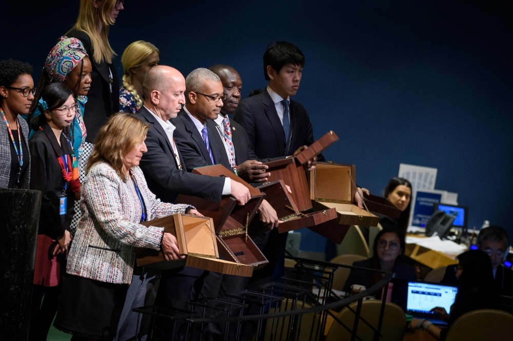 This handout photo released by the UN shows Conference Officers displaying empty ballot boxes before collecting Member States' ballots during elections by the General Assembly for fourteen members of the Human Rights Council at the UN in New York on Thursday. — AFP