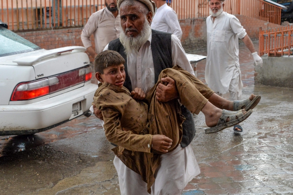 A volunteer carries an injured youth to hospital, following a bomb blast in Haska Mina district of Nangarhar Province, Afghanistan, on Friday. — AFP