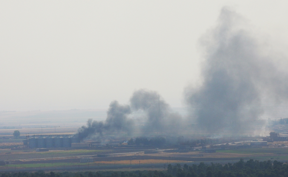 Smoke rises from a building near the Syrian town of Ras Al-Ain as seen from the Turkish border town of Ceylanpinar, Sanliurfa province, Turkey, on Friday. — Reuters