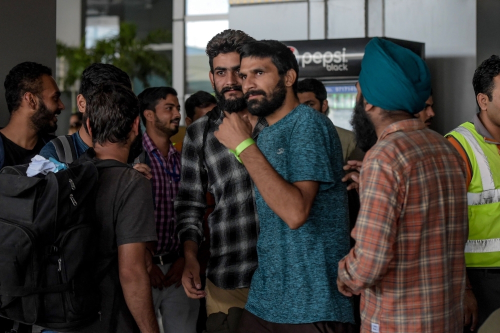 Indian nationals arrive at Indira Gandhi International airport in New Delhi on Friday, after being deported from Mexico as they tried to enter the United States. — AFP