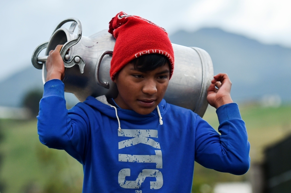 An Ecuadorean indigenous boy carries a jug with milk to sell in Cayambe, Ecuador, in this Oct. 16, 2019 file photo. — AFP