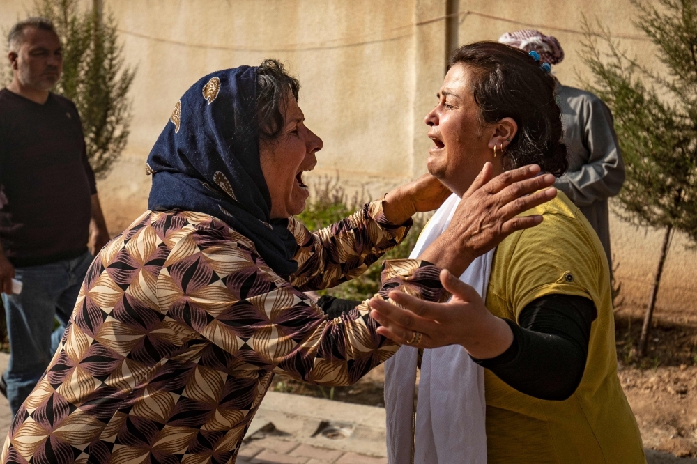 Women react as the body of a man killed during Turkish shelling in the area surrounding the Syrian Kurdish town of Ras Al-Ain arrives at a hospital in the nearby town of Tal Tamr following the announced cease-fire on Friday. — AFP