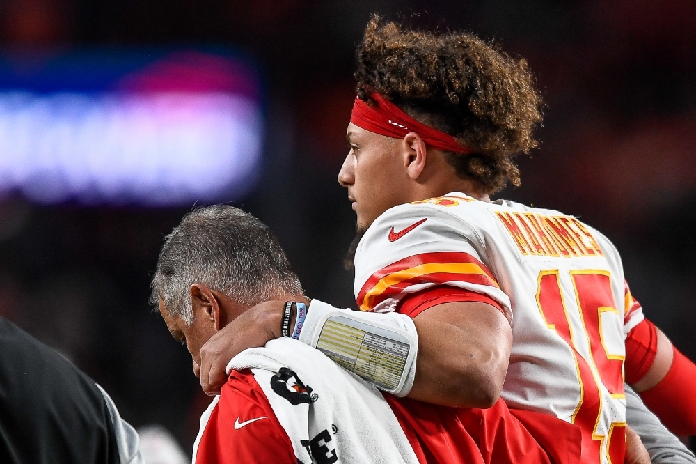 In this file photo taken on Oct. 17,  2019, Patrick Mahomes of the Kansas City Chiefs is helped off the field by trainers after sustaining an injury in the second quarter of a game against the Denver Broncos at Empower Field at Mile High in Denver, Colorado.    Mahomes has a dislocated right kneecap and will miss at least three weeks of the NFL season while recovering, according to multiple reports on Friday. — AFP