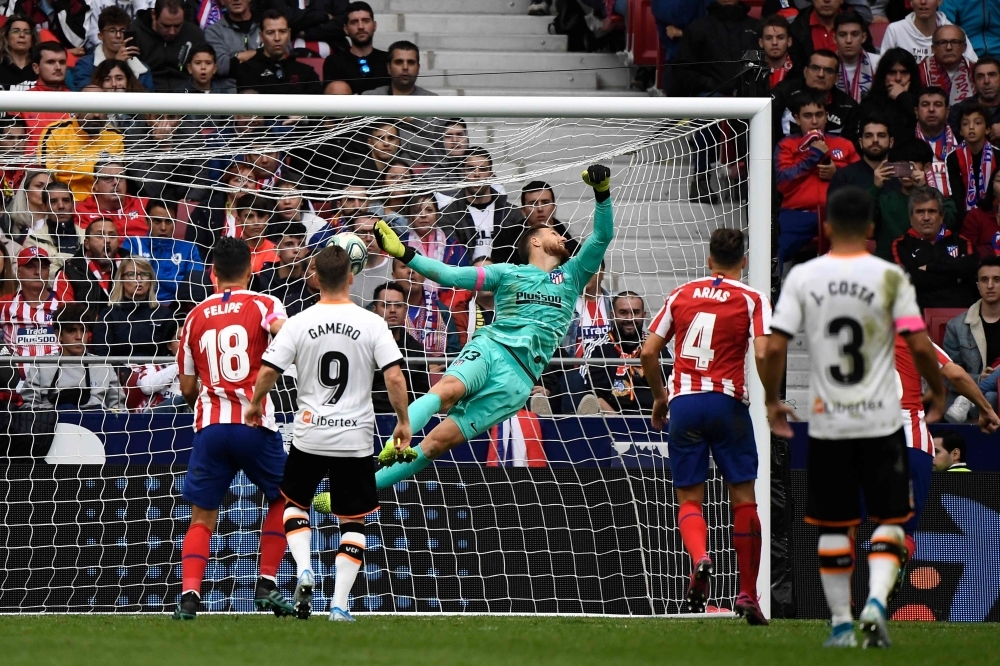 Atletico Madrid's Slovenian goalkeeper Jan Oblak (C) fails to stop a ball kicked by Valencia's Spanish midfielder Daniel Parejo during the Spanish league football match Club Atletico de Madrid against Valencia CF at the Wanda Metropolitano stadium in Madrid, on Saturday. — AFP