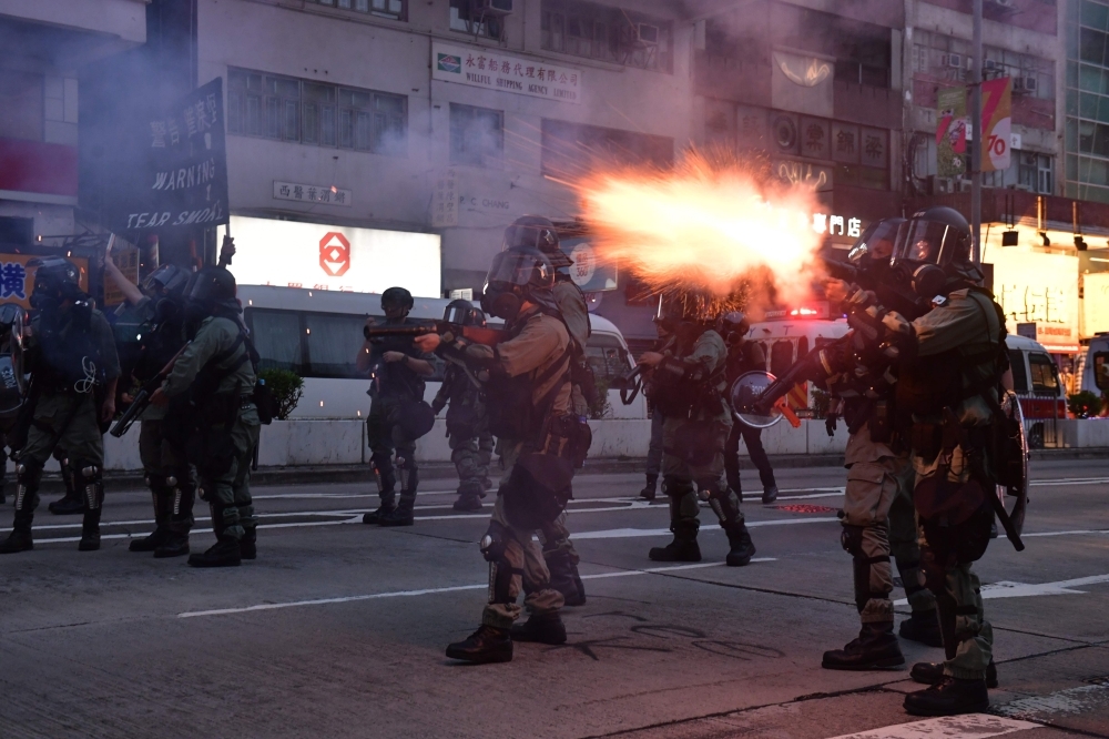 Riot police fire tear gas against protesters in Mongkok during a pro-democracy march in the Kowloon district in Hong Kong, Sunday. — AFP