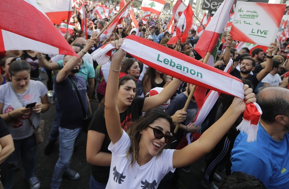 Lebanese demonstrators wave national flags on a highway linking Beirut to north Lebanon, in Zouk Mosbeh as they take part in a rally during the fourth day of demonstrations against tax increases and official corruption, on Sunday. Thousands continued to rally despite calls for calm from politicians and dozens of arrests. The demonstrators are demanding a sweeping overhaul of Lebanon's political system, citing grievances ranging from austerity measures to poor infrastructure. — AFP