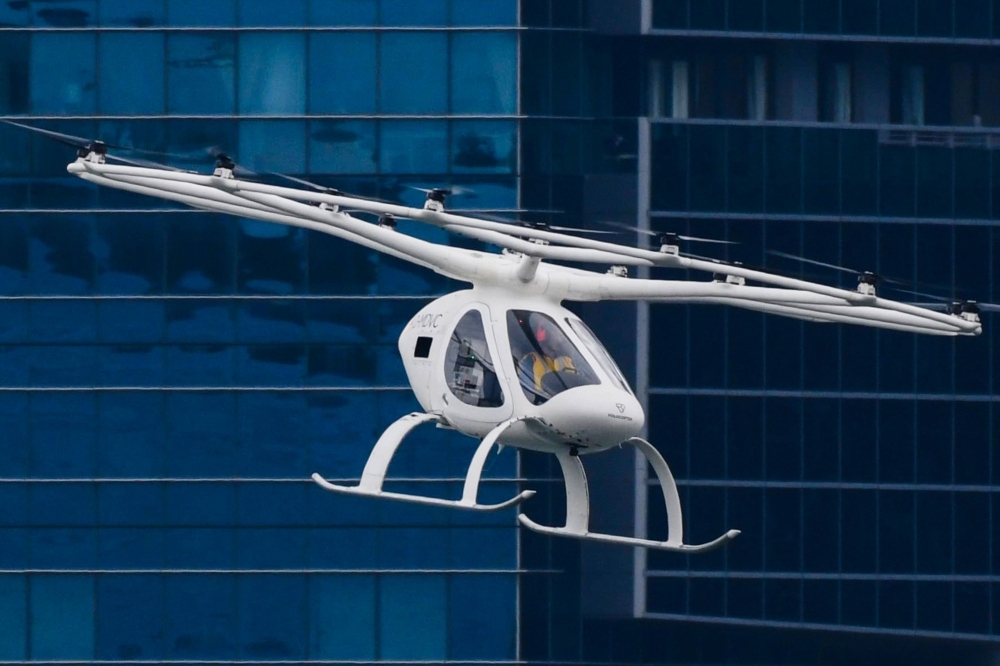 A Volocopter unmanned air taxi transport flies over Marina Bay during test flight with a safety pilot at the 26th Intelligent Transport Systems World Congress (ITSWC) in Singapore on Tuesday. — AFP