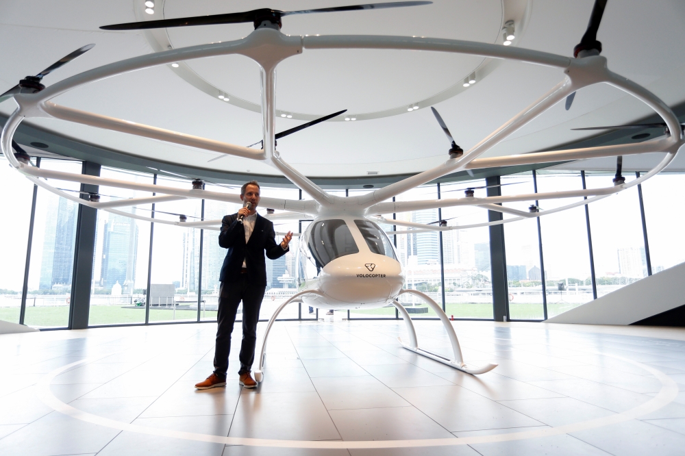 A Volocopter unmanned air taxi transport flies over Marina Bay during test flight with a safety pilot at the 26th Intelligent Transport Systems World Congress (ITSWC) in Singapore on Tuesday. — AFP