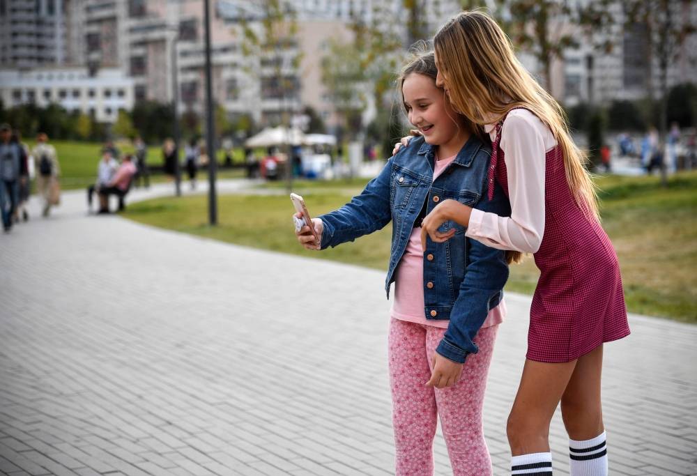 Russian child blogger Liza Anokhina, right, 12, participates in a shoot for her blog in a Moscow park in this Sept. 13, 2019 file photo. — AFP