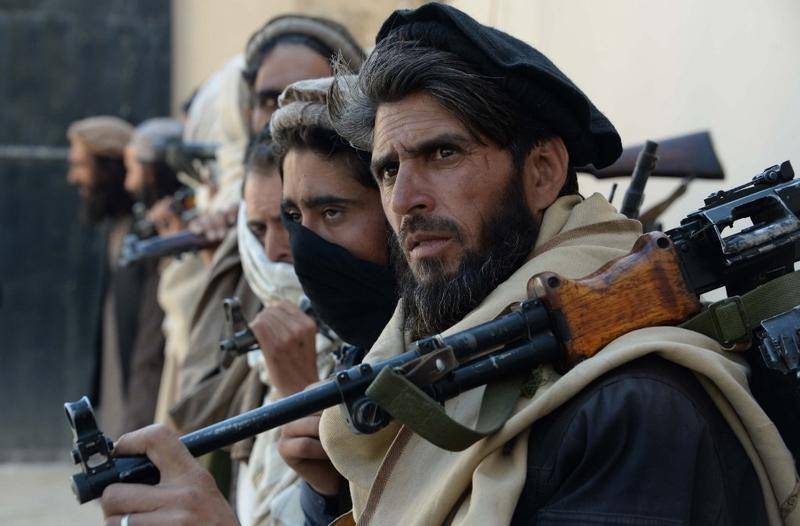 Afghan alleged former Taliban fighters carry their weapons before handing them over as part of a government peace and reconciliation process at a ceremony in Jalalabad, Afghanistan, in this Feb. 24, 2016 file photo. — AFP