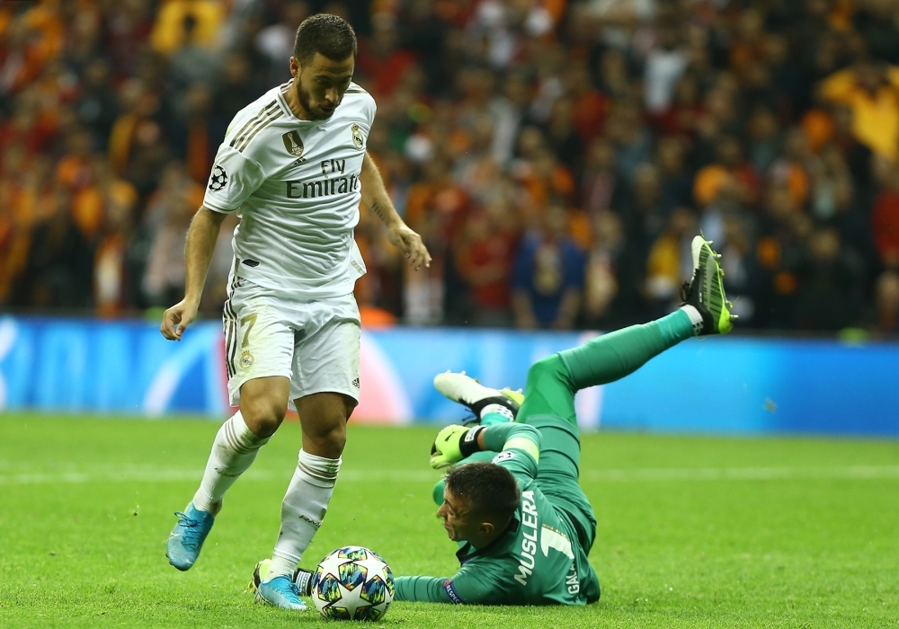 Real Madrid's Belgian forward Eden Hazard (L) runs with the ball past Galatasaray's Uruguayan goalkeeper Fernando Muslera during the UEFA Champions League group A football match between Galatasaray and Real Madrid at the Ali Sami Yen Spor Kompleksi in Istanbul, on Tuesday. — AFP