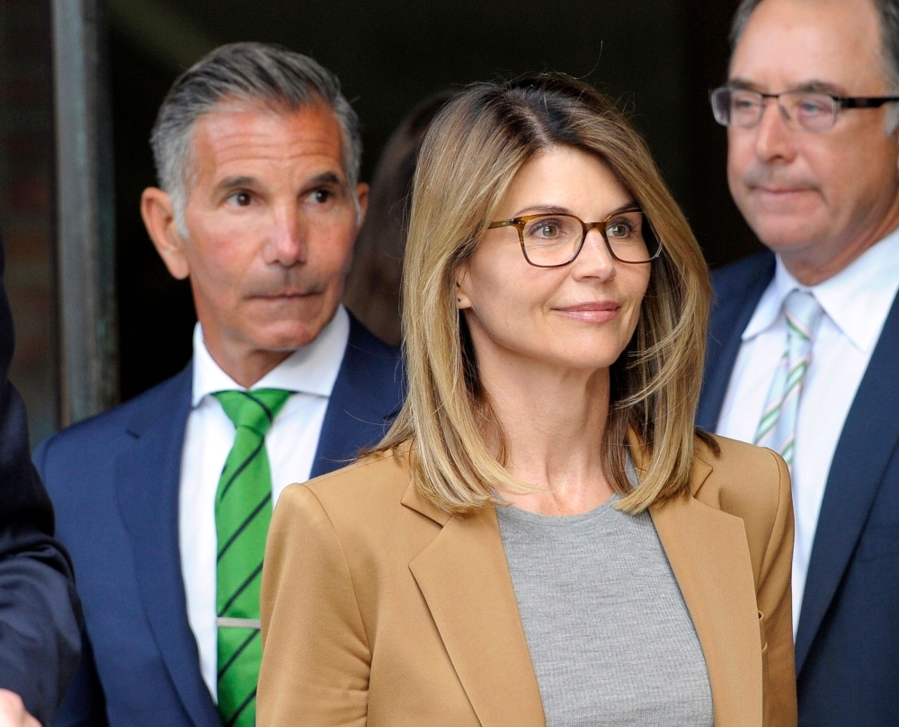Actress Lori Loughlin, with husband Mossimo Giannulli, left, exits the courthouse after facing charges for allegedly conspiring to commit mail fraud and other charges in the college admissions scandal at the John Joseph Moakley United States Courthouse in Boston in this April 03, 2019 file photo. — AFP