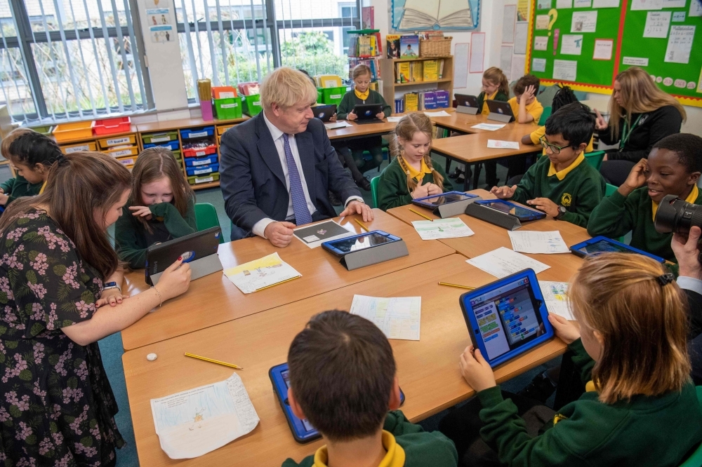 Britain's Prime Minister Boris Johnson speaks to pupils as he visits Middleton Primary School in Milton Keynes, southern England, on Friday. — AFP