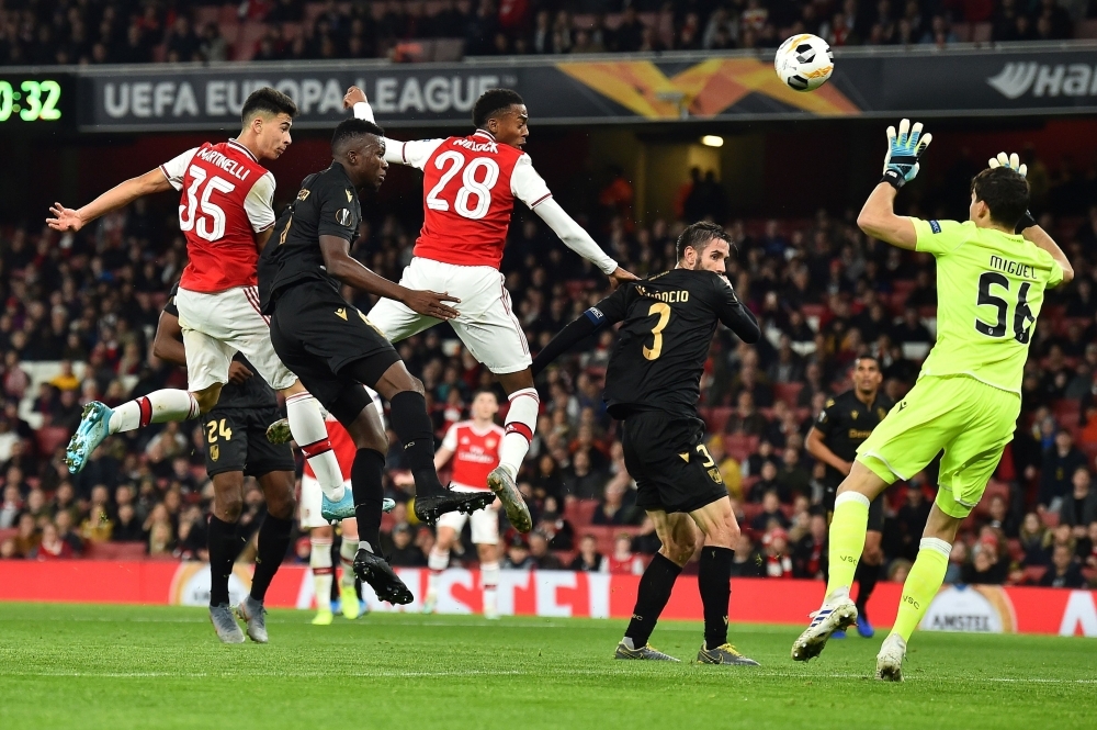 Arsenal's Brazilian striker Gabriel Martinelli (L) heads the ball past Vitoria Guimaraes' Portuguese goalkeeper Miguel Silva (R) to score the equalizing goal during their UEFA Europa league Group F football match between Arsenal and Vitoria Guimaraes at the Emirates stadium in London on Thursday. — AFP