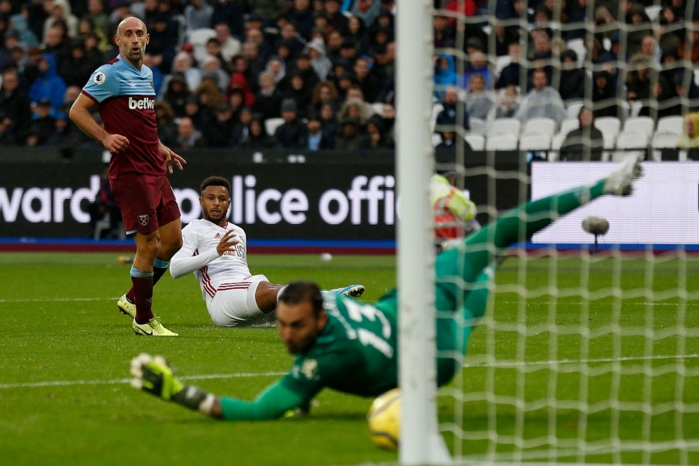 Sheffield United's French striker Lys Mousset (C) scores his team's first goal past West Ham United's Spanish goalkeeper Roberto (R) during the English Premier League football match between West Ham United and Sheffield United at The London Stadium, in east London, on Saturday. — AFP