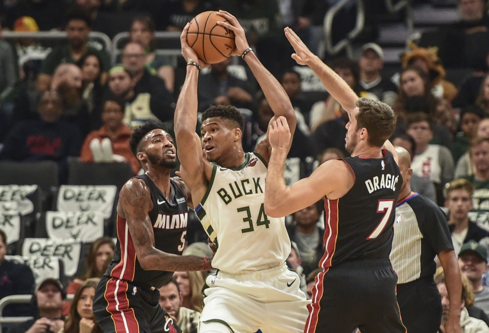 Milwaukee Bucks forward Giannis Antetokounmpo (34) gets pressure from Miami Heat forward Derrick Jones Jr. (5) and guard Goran Dragic (7) in the second quarter at Fiserv Forum, Milwaukee, WI, USA, on Saturday. — AFP