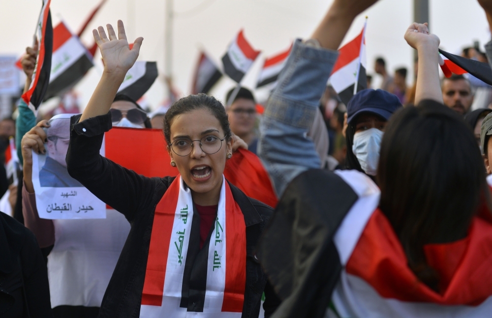 Iraqis take part in an anti-government demonstration, on Monday in the central city of Hila. The Iraqi army today announced it would impose an overnight curfew in the capital as students and schoolchildren joined spreading protests to demand an overhaul of the government. Swaths of Iraq have been engulfed by demonstrations over unemployment and corruption this month that have evolved into demands for regime change. — AFP