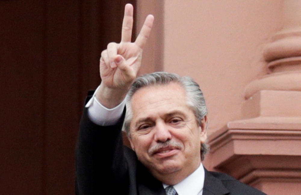 President-elect Alberto Fernandez flashes a V sign as he leaves after a meeting with Argentina's President Mauricio Macri at the presidential palace Casa Rosada, after Fernandez won in the presidential elections, in Buenos Aires on Monday. -Reuters