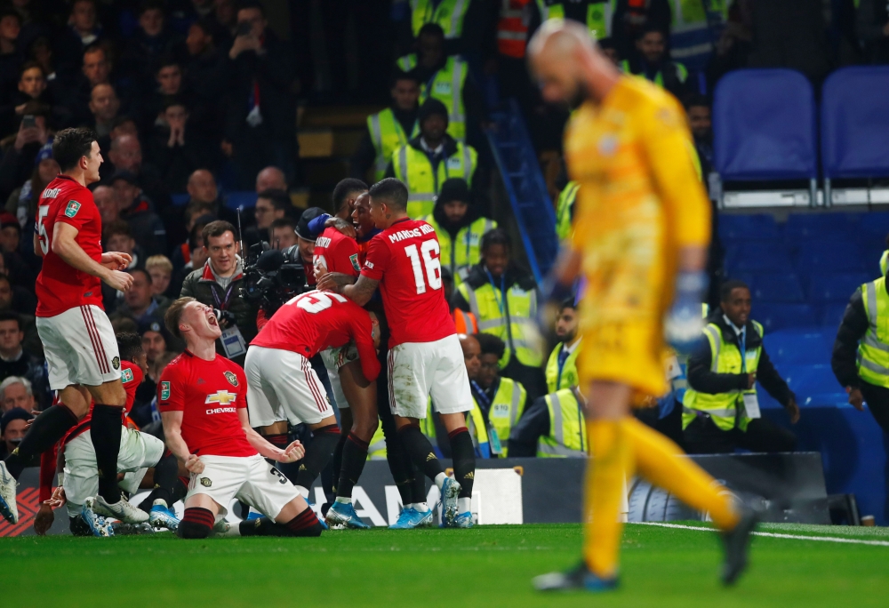 Manchester United's Marcus Rashford celebrates scoring their second goal with Scott McTominay and teammates as Chelsea's Willy Caballero looks dejected during the fourth round of the Carabao Cup at Stamford Bridge, London, Britain, on Wednesday. — Reuters