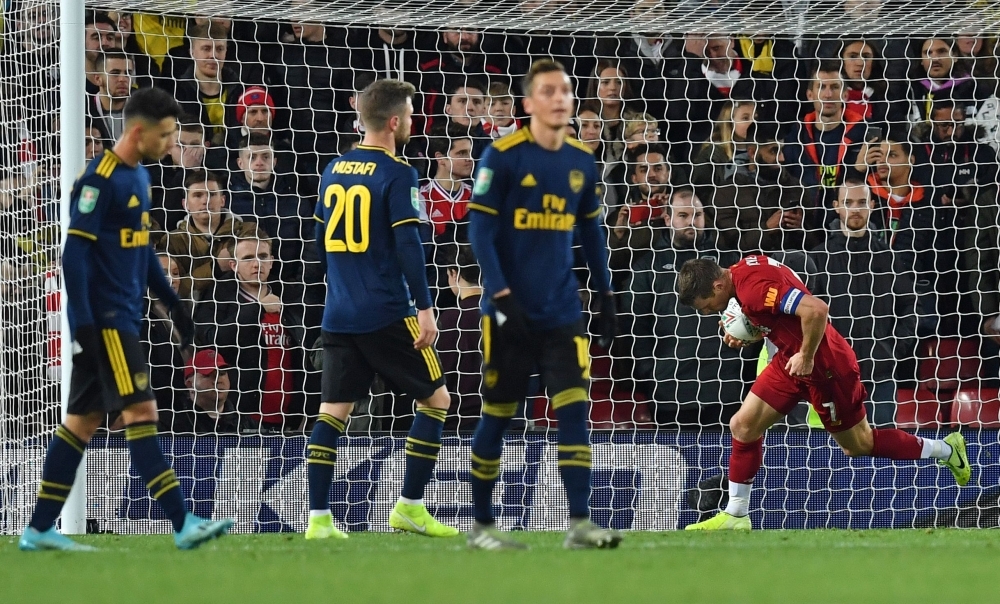 Liverpool's English midfielder James Milner (R) passes Arsenal's Brazilian striker Gabriel Martinelli (L) as he celebrates scoring his team's second goal, from the penalty spot during the English League Cup fourth round football match between Liverpool and Arsenal at Anfield in Liverpool, north west England on Wednesday. — AFP