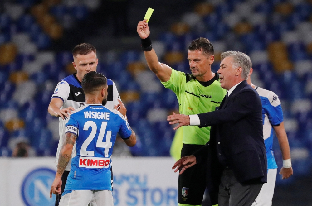 Napoli's Lorenzo Insigne is shown a yellow card by referee Piero Giacomelli as Napoli coach Carlo Ancelotti reacts during the Serie A match against Atalanta at Stadio San Paolo, Naples, Italy, on Wednesday. — Reuters