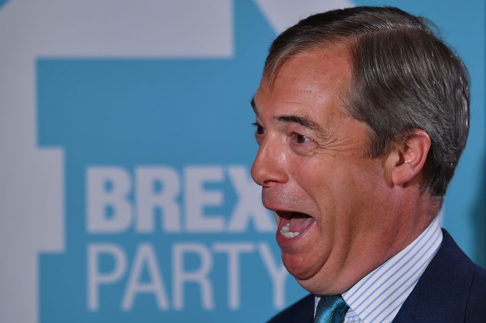 Brexit Party leader Nigel Farage speaks to a journalist during an event to launch the Brexit Party general election campaign in London on Friday. — AFP