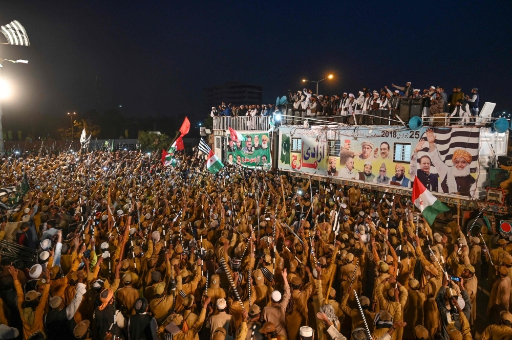 Supporters of Islamic political party Jamiat Ulema-e-Islam (JUI-F) gather beside a stage during an anti-government 