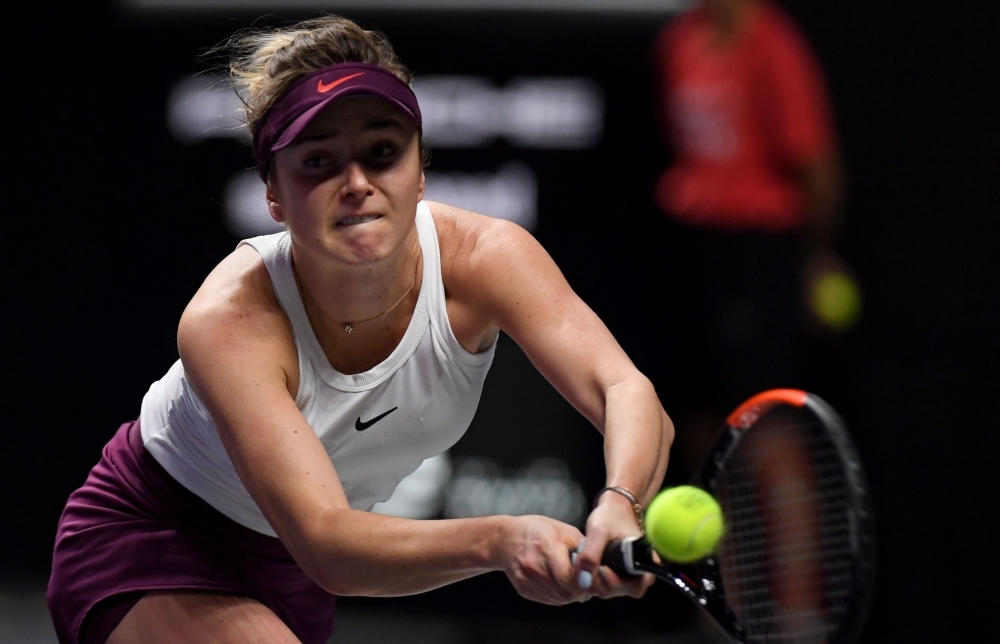 Elina Svitolina of Ukraine hits a return against Belinda Bencic of Switzerland in their women's singles match in the WTA Finals tennis tournament in Shenzhen, on Saturday. — AFP