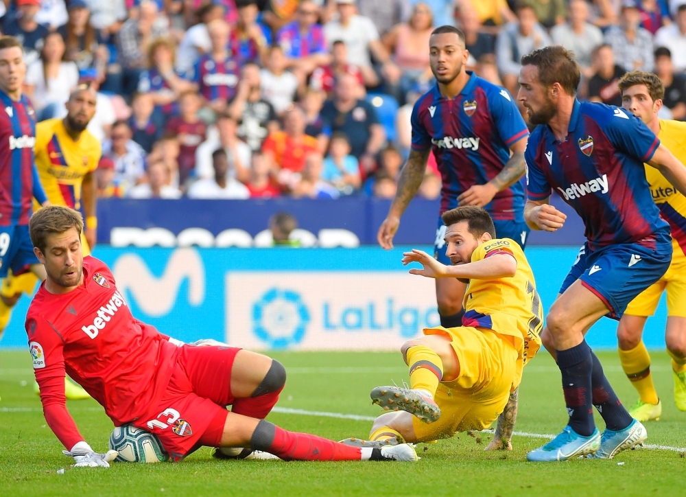 Levante's Spanish goalkeeper Aitor Fernandez (L) vies with Barcelona's Argentinian Forward Lionel Messi during the Spanish League football match between Levante UD and FC Barcelona at the Ciutat de Valencia stadium in Valencia, on Saturday. — AFP