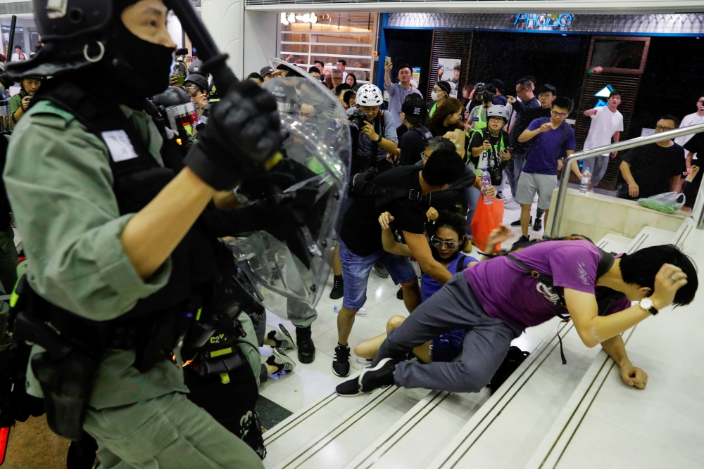 Riot police disperse anti-government protesters at a shopping mall in Tai Po, Hong Kong, on Sunday. -Reuters