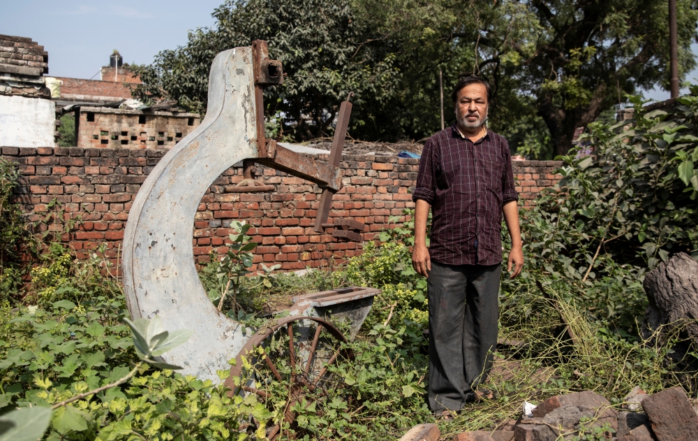 Mohammed Shahid, grandson of Haji Abdul Gaffar, the last imam of Babri mosque, poses in front of a machinery of sawmill which was burned down by a mob after the demolition of the mosque, in Ayodhya, India, in this Oct. 22, 2019 file photo. — Reuters