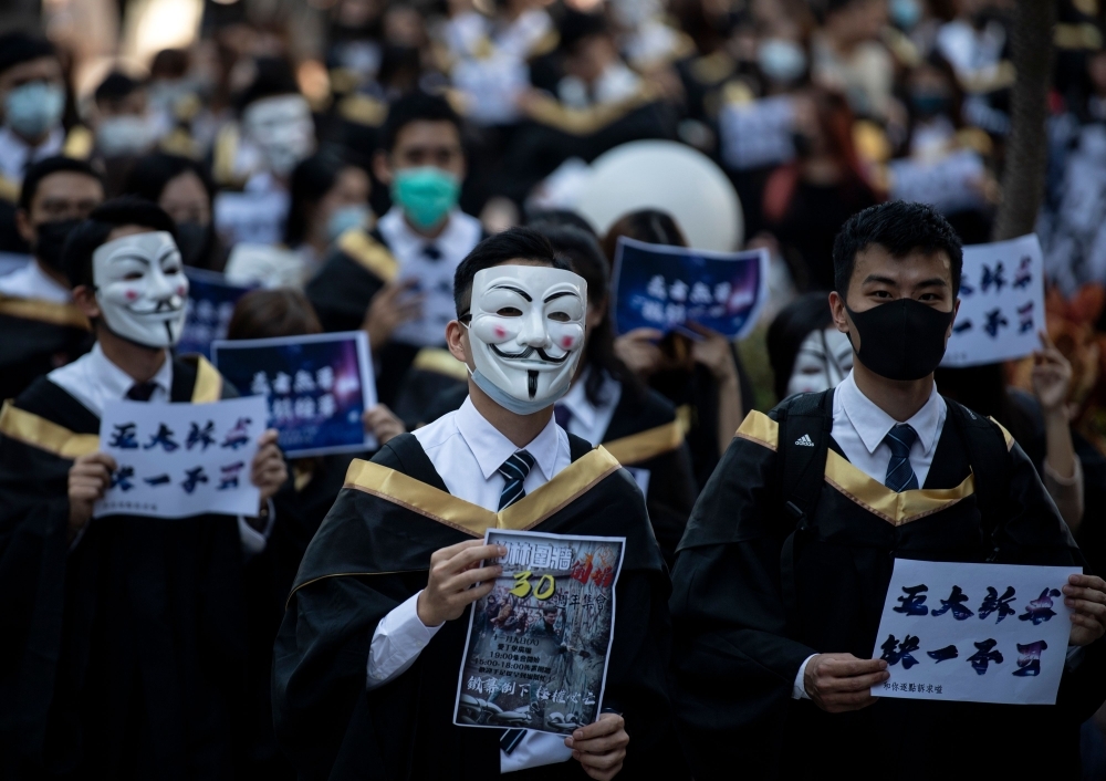 University students wear Guy Fawkes masks, popularized by the 'V For Vendetta' comic book film, before their graduation ceremony at the Hong Kong Polytechnic University in Hong Kong on Tuesday. -Courtesy photo