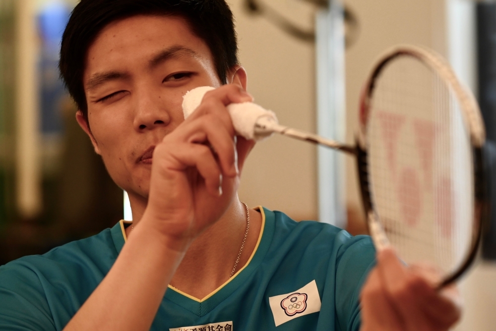 This picture taken on Aug. 30, 2019, shows world number two badminton player Chou Tien-chen of Taiwan checking his racket during an interview with Agence France-Presse in Taipei. Chou Tien-chen is taking the unusual step of gearing up for the 2020 Olympics without a coach, with his longtime physio and confidante shepherding him towards Tokyo gold. — AFP