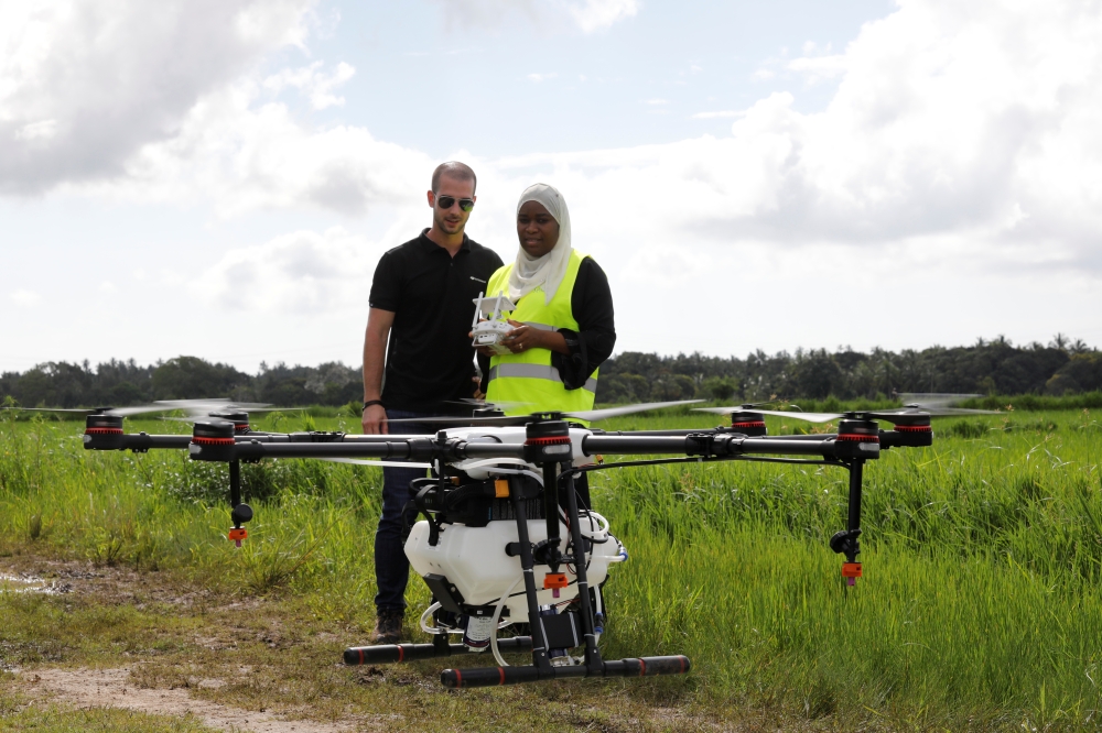 Tanzanian drone pilot Khadijah Abdulla Ali, right, flies a customized DJI Agras MG-1S drone next to DJI's Enterprise Product Manager Eduardo Rodriguez during a training flight as part of a test in using drone technology in the fight against malaria, near Zanzibar City, on the island of Zanzibar, Tanzania, October 31, 2019. Picture taken October 31, 2019. REUTERS/Baz Ratner