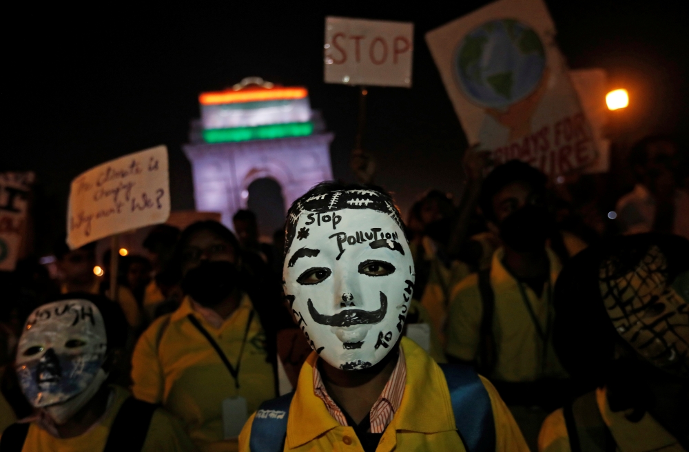 A boy wearing a mask attends a protest demanding that the government take immediate steps to control air pollution in New Delhi, India, on Tuesday. -Reuters
