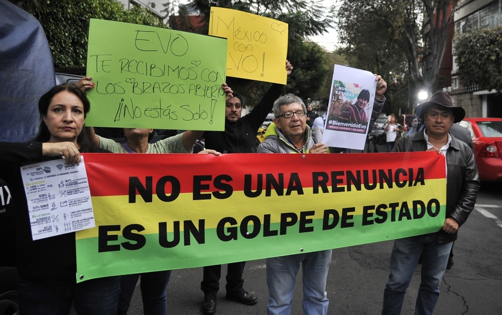 People demonstrate in support of Bolivian ex-President Evo Morales, holding a banner that reads 'It's not a resignation, It's a coup', in front of the Bolivian embassy in Mexico City, on Monday. - AFP
