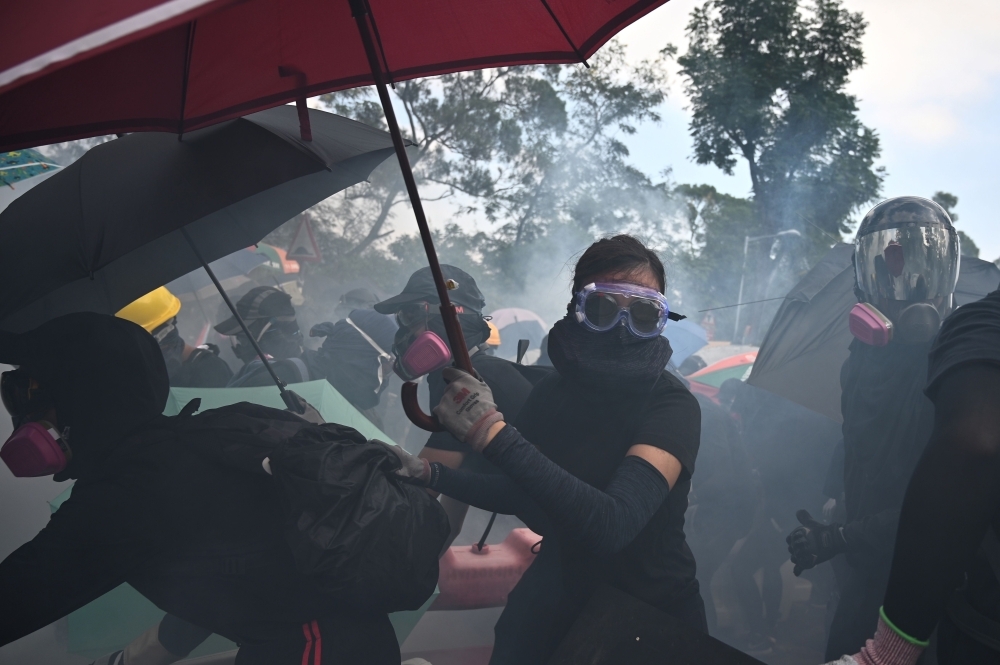 Police fire tear gas towards protesters at the Chinese University of Hong Kong (CUHK), in Hong Kong on Tuesday. -AFP 