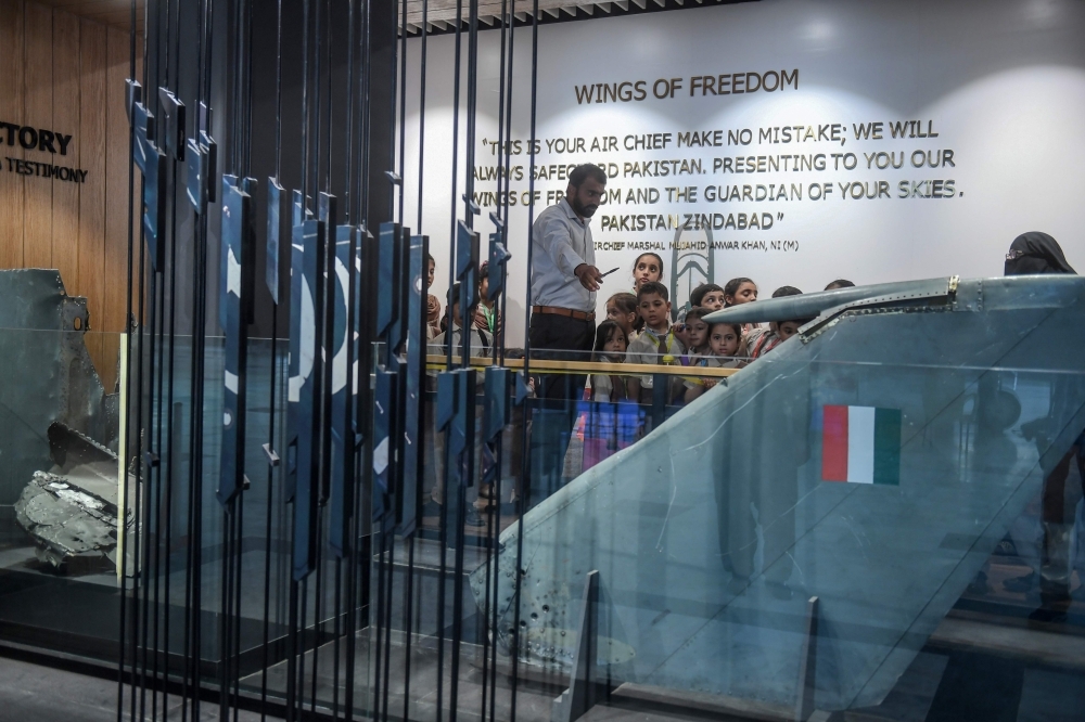Students look at a part of an Indian Mig-21 fighter aircraft which was being flown by  Indian pilot Wing Commander Abhinandan Varthaman whose plane was shot down over Kashmir earlier this year, put on display at Pakistan Air Force Museum in Karachi, on Tuesday. — AFP